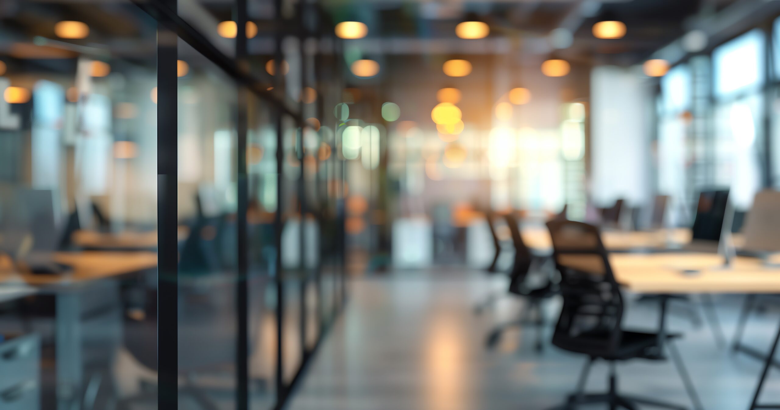 Abstract blurred background of modern office with glass walls shows desks and chairs with computer tax plan